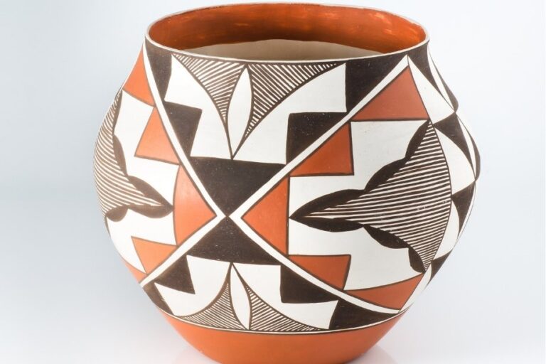 An authentic Native American pottery vessel hand-painted with traditional geometric tribal symbols.