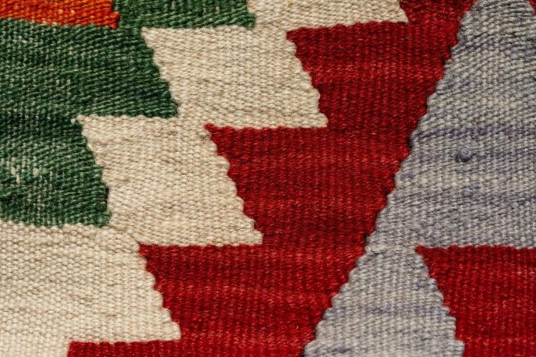 A tight detail shot highlighting the wool weave and geometric lines of a Navajo rug pattern.