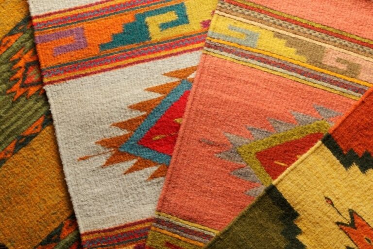 A vibrant showroom stack of hand-woven Southwestern native American wool rugs.